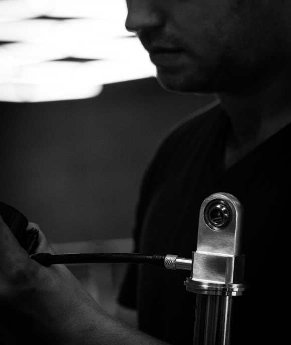 Technicien Nimbus assemblant une suspension oléopneumatique avec flexible tressé