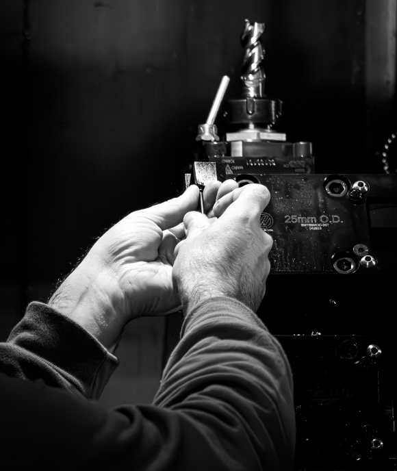 Mains sur tour CNC usinant des composants Nimbus