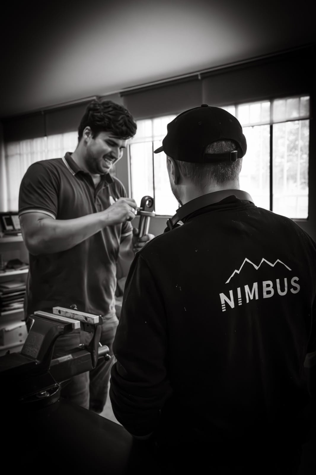 Deux membres de l'équipe Nimbus discutent d'une pièce de suspension à l'atelier